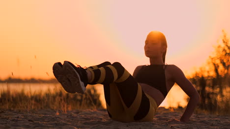 Fitte,-Gesunde-Frau-Macht-Stretching-Auf-Einer-Yogamatte-Am-Strand-Am-Meer,-Macht-Bauchpressen,-Training-Und-Lebensstil,-Sit-Ups-Training-Am-Dock-Strand-Im-Sonnenuntergang